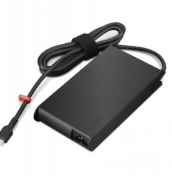 Musta, suorakulmainen Lenovo 135W USB-C -verkkovirtalähde ja kaapeli punaisella yksityiskohdalla pöydällä.